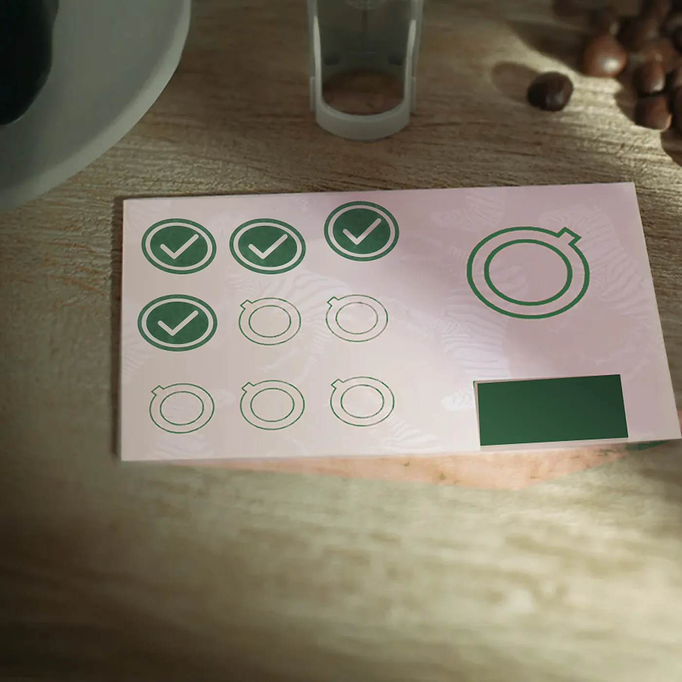 Une carte à tampons papier posée sur une table : quatre tampons, cinq cases vides