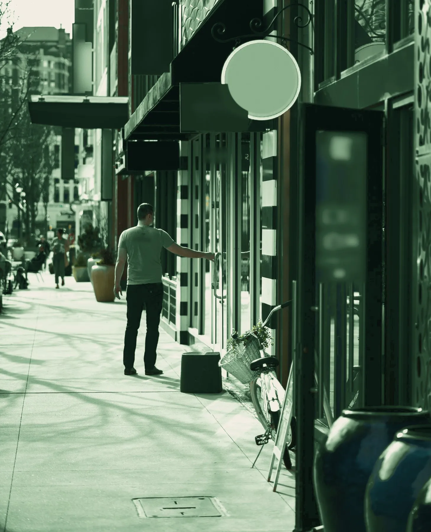 Rue commerçante, un client pousse la porte d’une boutique, en tons verts